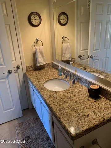 a bathroom with a granite countertop sink and a mirror