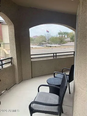 a balcony with table and chairs
