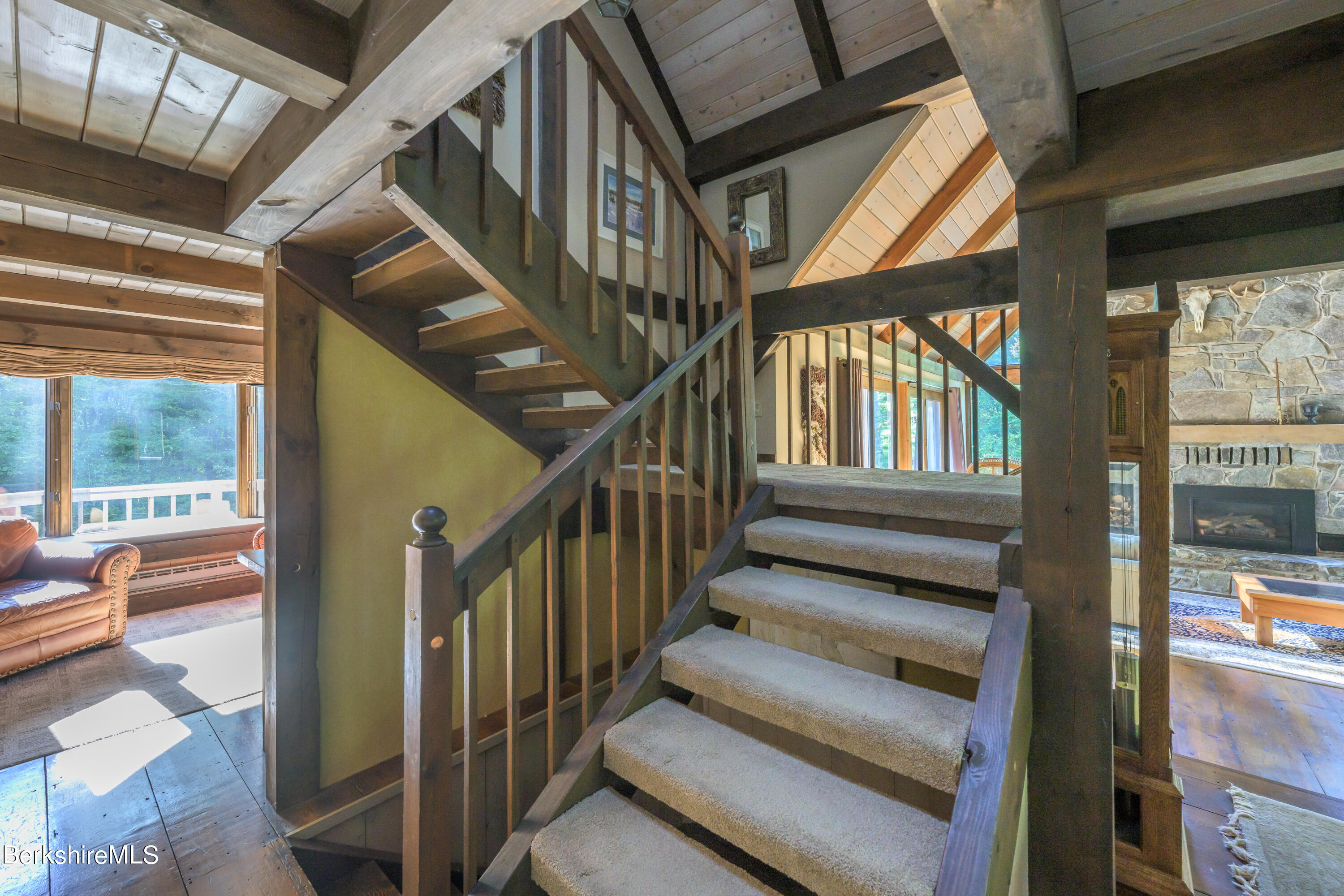 248 Osceola Notch Road Lenox, MA 01254 - Photo 15 of 43 a view of staircase with lots of frames on wall and windows