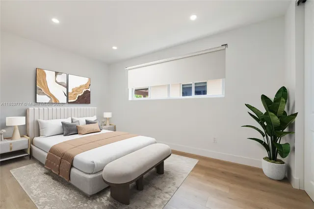 a bedroom with a large bed and a potted plant