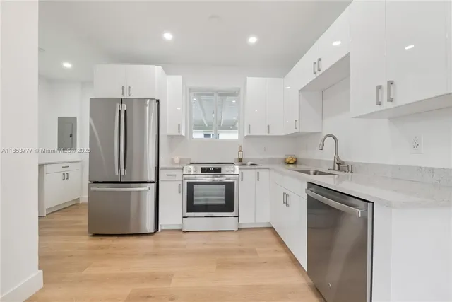 a kitchen with stainless steel appliances granite countertop a refrigerator sink and stove