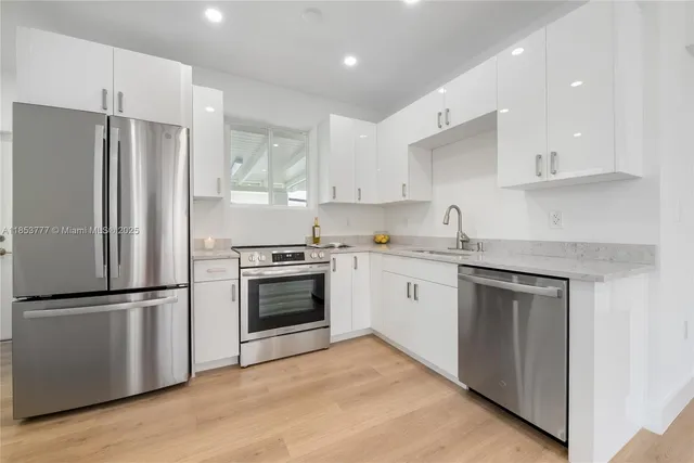 a kitchen with a refrigerator stove and white cabinets