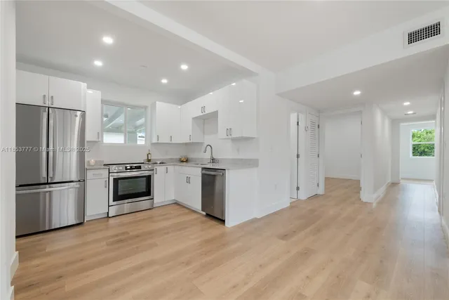 a kitchen with a refrigerator and a stove top oven