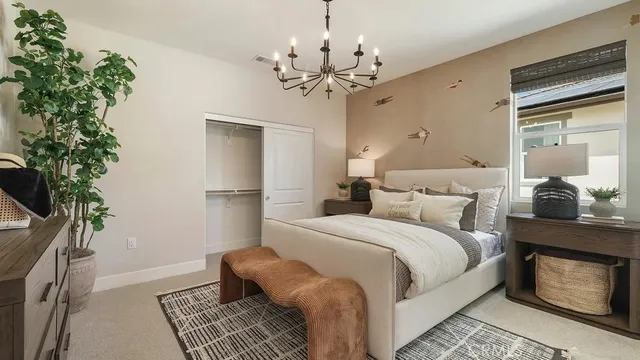 a bed room with a bed window and a chandelier