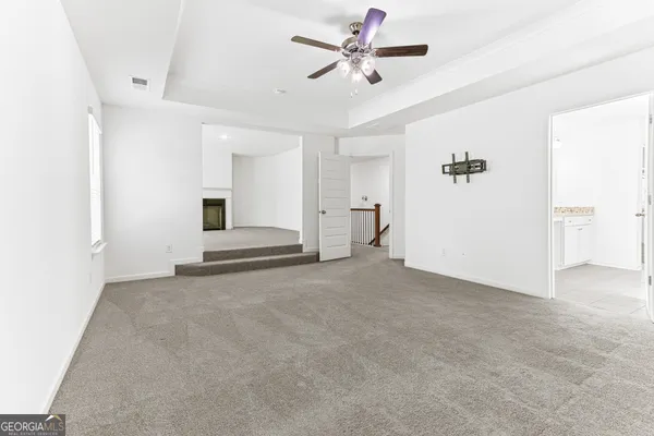 a view of a livingroom with a ceiling fan and entryway
