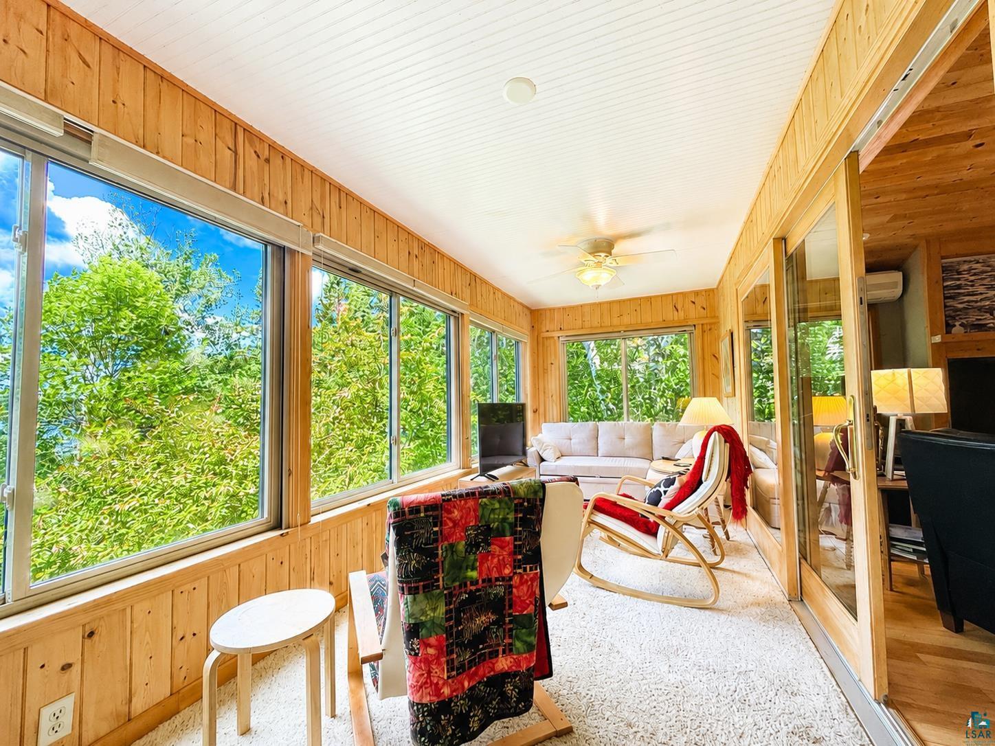 1787 North Bay Road Ely, MN 55731 - Photo 13 of 40 Sunroom featuring natural wood paneling, extensive window glazing, a white beadboard ceiling, and plush white carpeting