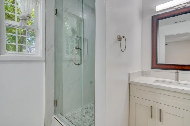 a bathroom with a granite countertop sink a toilet and shower