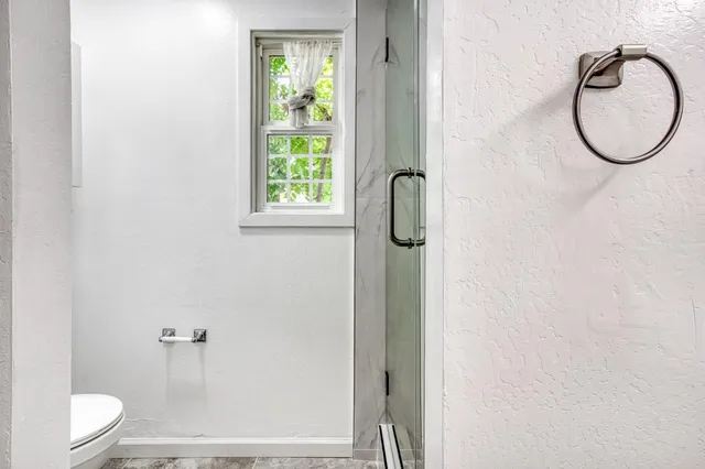 a bathroom with a granite countertop bathtub shower sink vanity and toilet