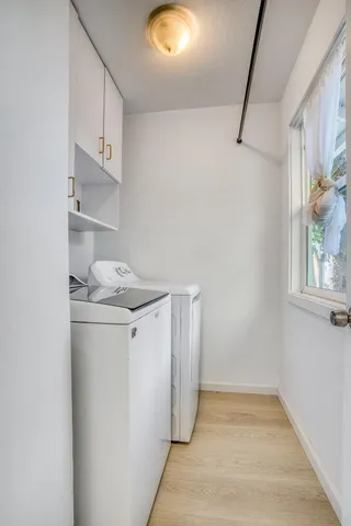 a backyard of a house with table and chairs under an umbrella