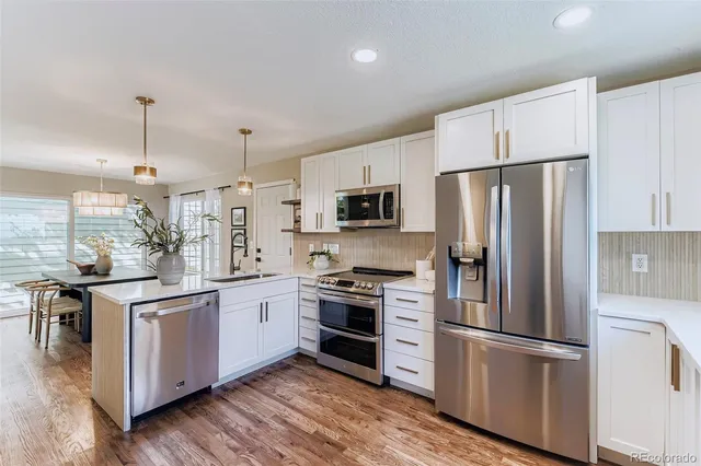 a kitchen with stainless steel appliances a refrigerator sink and microwave