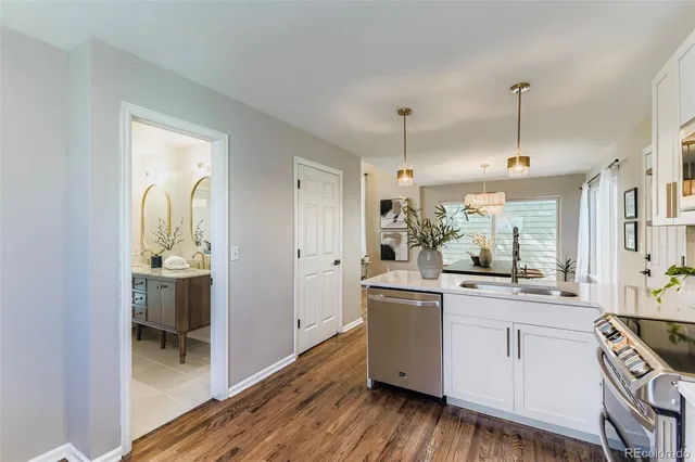 a kitchen with white cabinets and sink