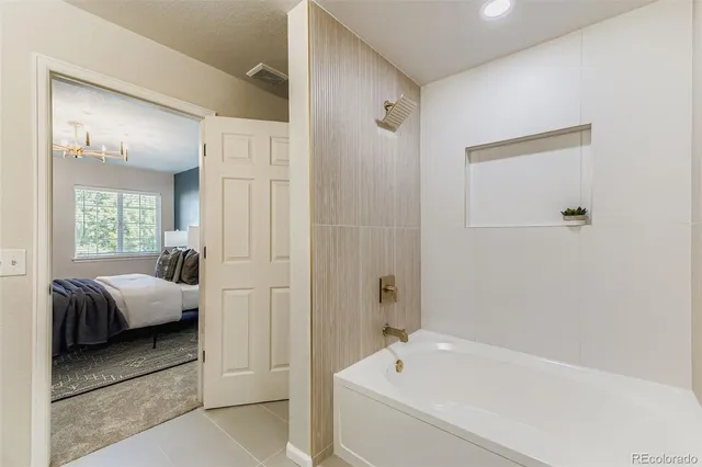 a en suite bathroom with a tub shower and bedroom
