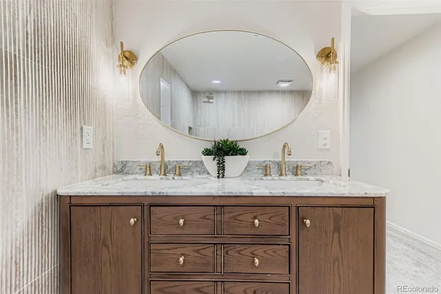 a bathroom with a granite countertop sink a mirror and vanity
