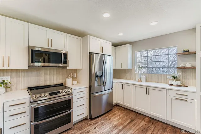 a kitchen with white cabinets and stainless steel appliances