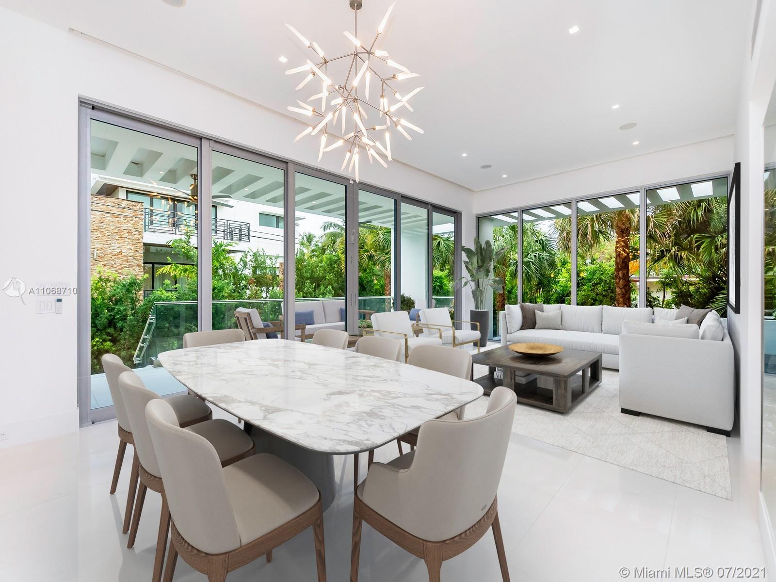 761 Glenridge Road Key Biscayne, FL 33149 - Photo 2 of 19 a view of a dining room with furniture large windows and wooden floor