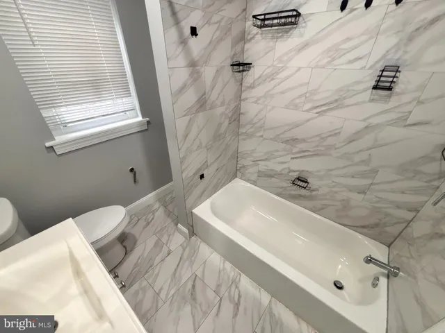 a bathroom with a tub sink and shower