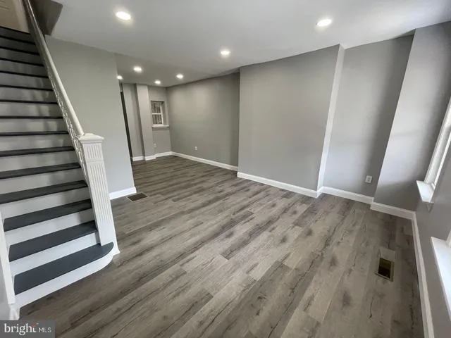 an empty room with wooden floor and entryway