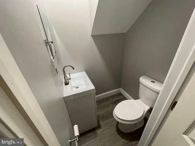 a white toilet sitting next to a sink and vanity