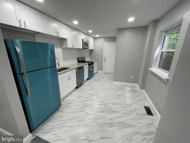 a kitchen with refrigerator a sink and a stove