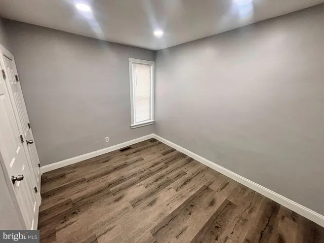 an empty room with wooden floor and window