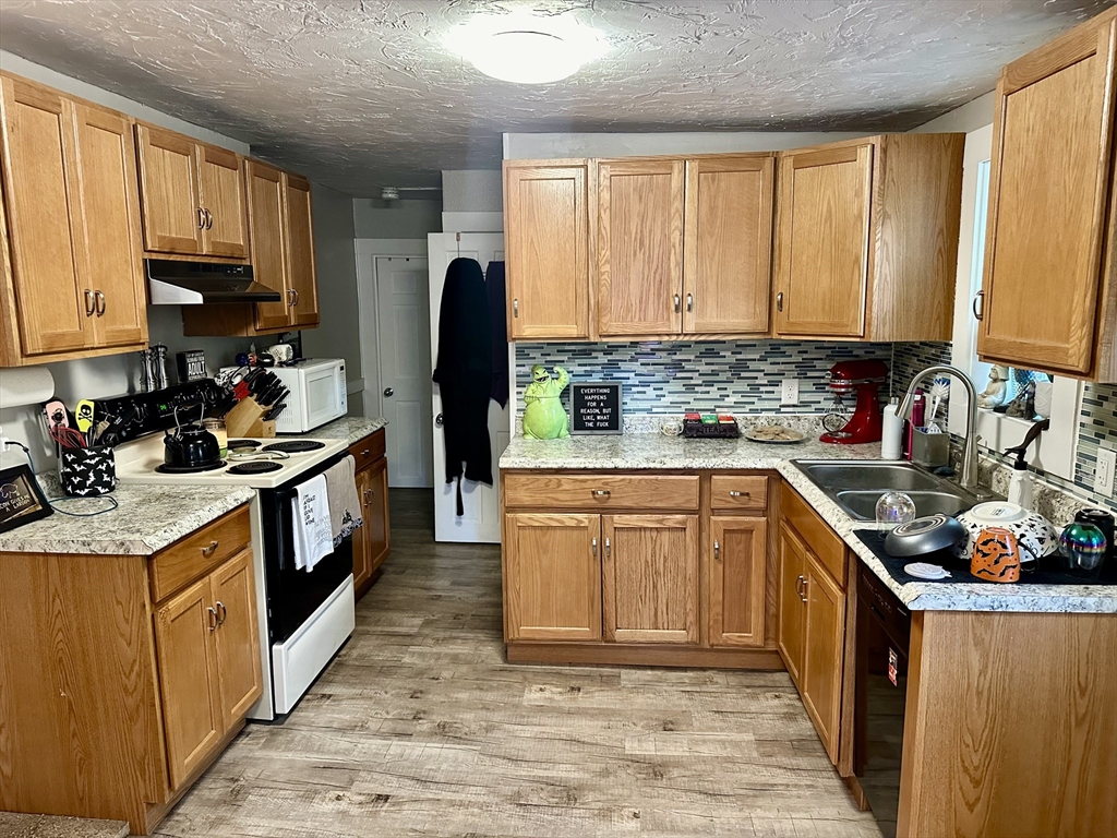1271 Main Street Leicester, MA 01524 - Photo 11 of 23 a kitchen with stainless steel appliances granite countertop a stove a sink dishwasher and a refrigerator