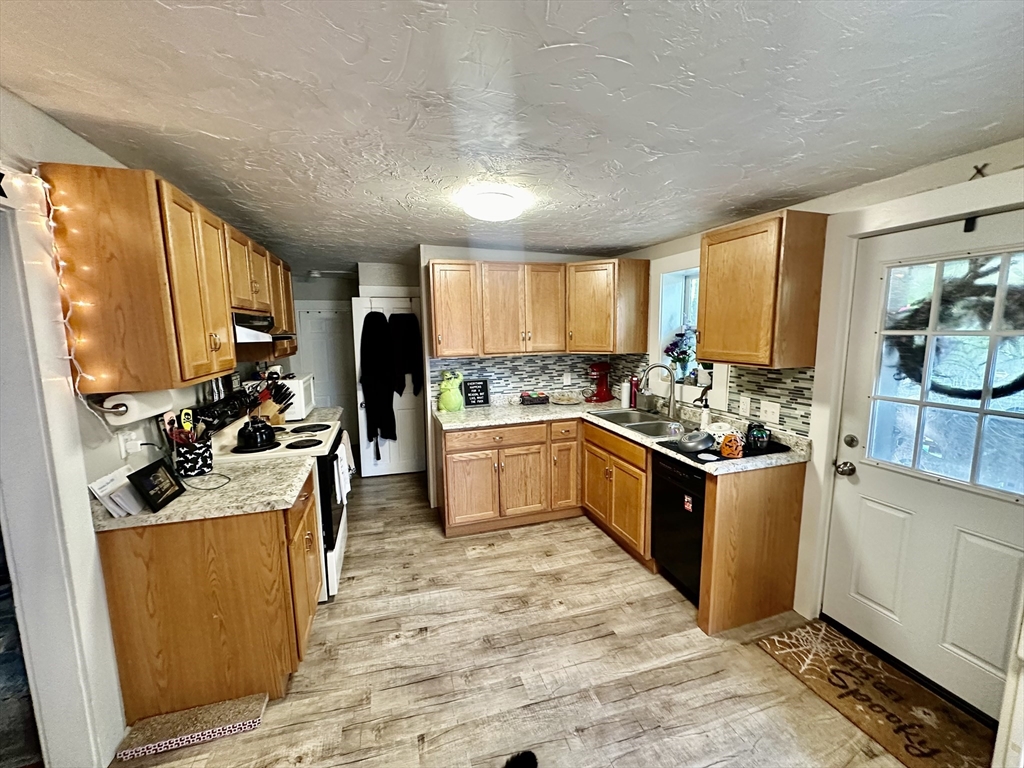 1271 Main Street Leicester, MA 01524 - Photo 10 of 23 a kitchen with a refrigerator a stove top oven a sink dishwasher and cabinets with wooden floor