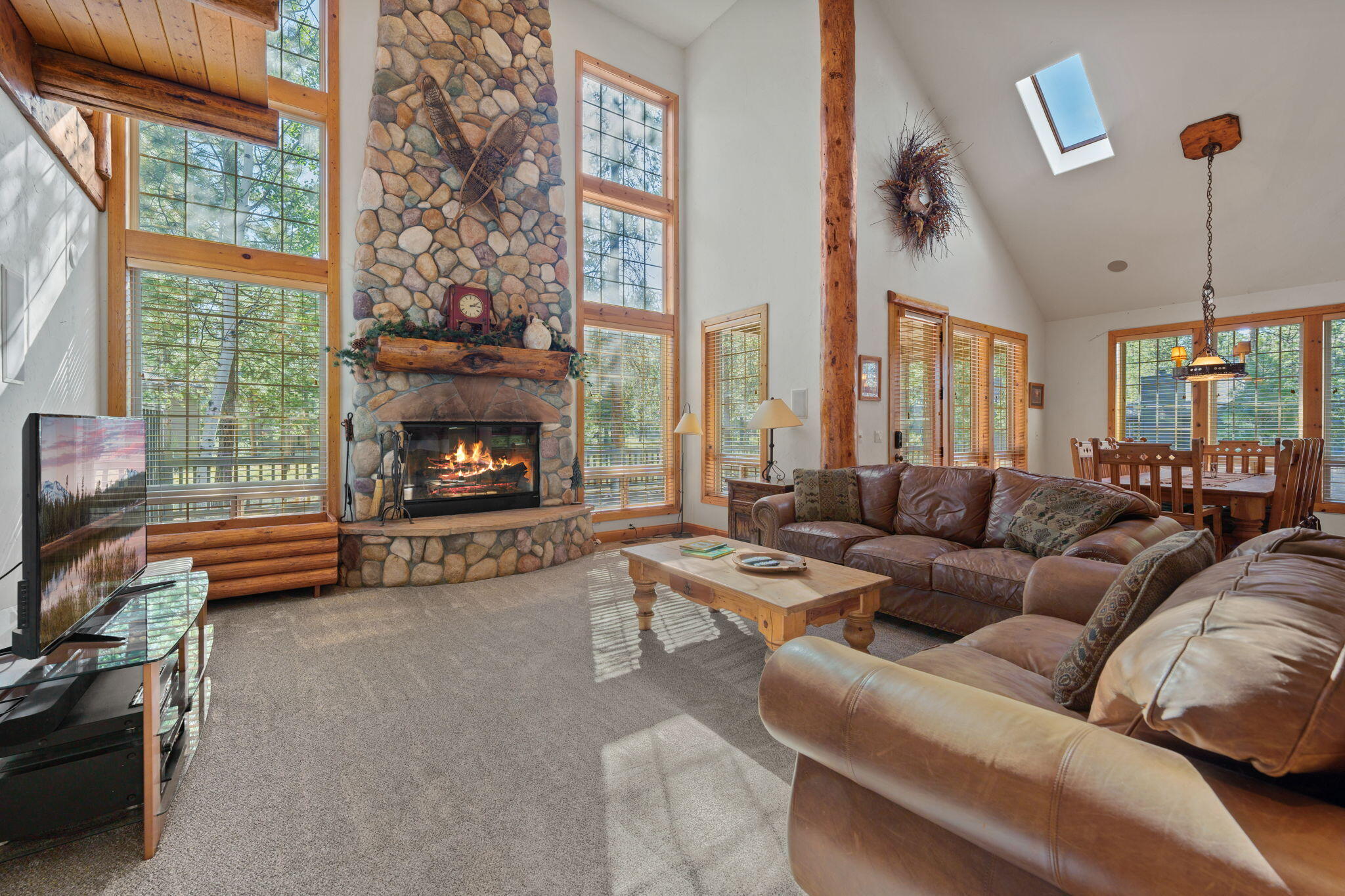 58026 Kinglet Road Sunriver, OR 97707 - Photo 6 of 39 a living room with furniture a fireplace and a floor to ceiling window
