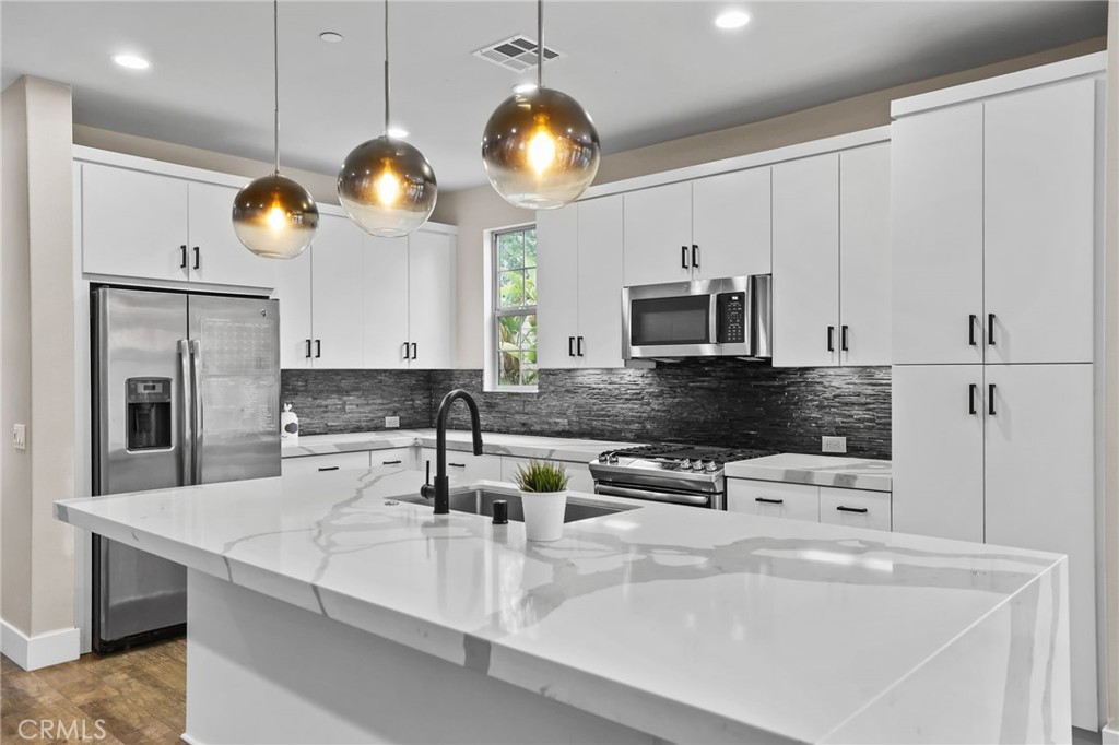 51 Prominence Lake Forest, CA 92630 - Photo 14 of 60 a kitchen with stainless steel appliances a stove a microwave and a refrigerator