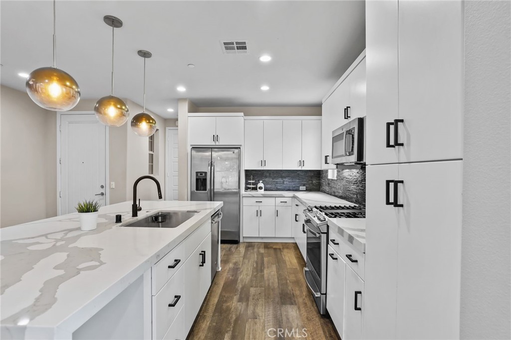 51 Prominence Lake Forest, CA 92630 - Photo 15 of 60 a kitchen with white cabinets appliances and a chandelier