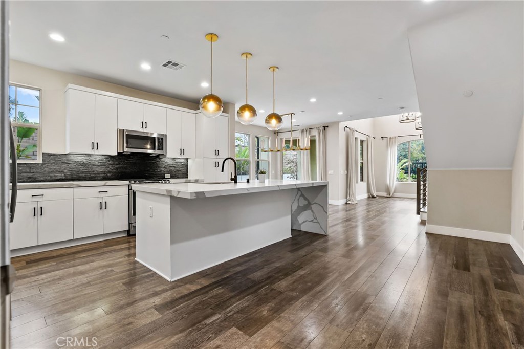51 Prominence Lake Forest, CA 92630 - Photo 2 of 60 a large kitchen with stainless steel appliances kitchen island granite countertop a stove a sink a refrigerator and a microwave