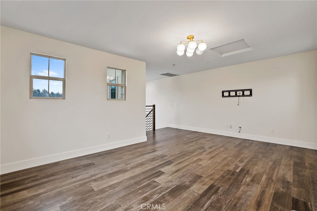 51 Prominence Lake Forest, CA 92630 - Photo 34 of 60 a view of an empty room with wooden floor and a chandelier