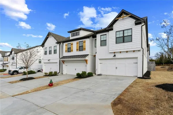 a kitchen with kitchen island a refrigerator a stove a dining table and chairs with wooden floor