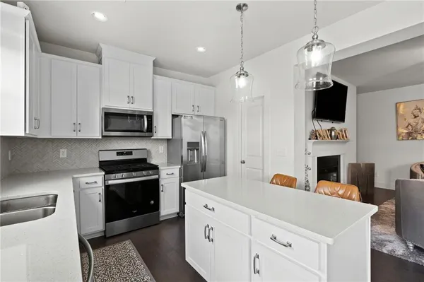 a kitchen with stainless steel appliances a stove refrigerator sink and microwave