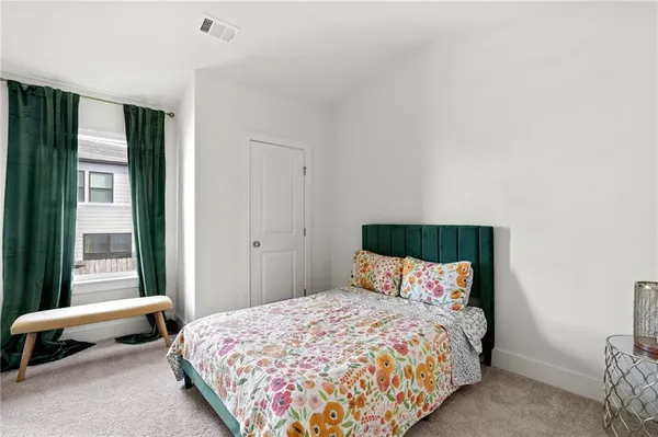 a bedroom with a bed and a painting on the wall