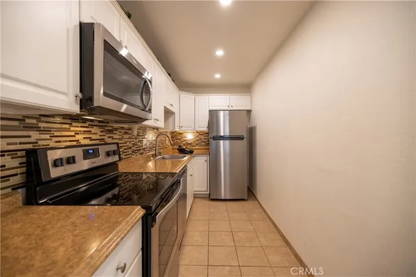 a kitchen with stainless steel appliances a stove a refrigerator and a microwave