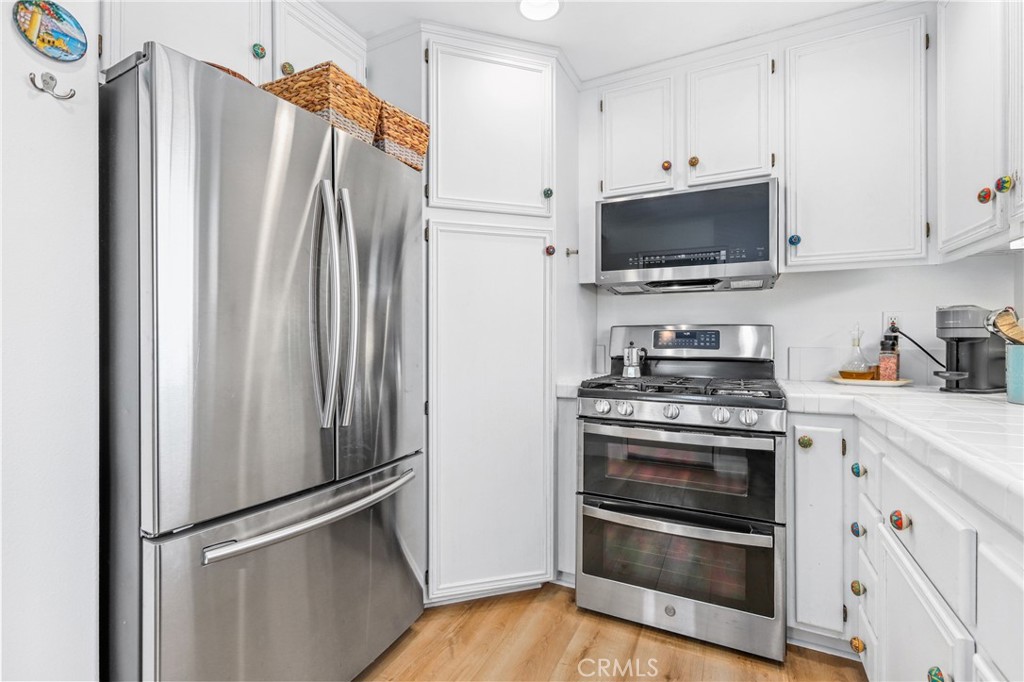 59 Red Bud Aliso Viejo, CA 92656 - Photo 17 of 34 a kitchen with stainless steel appliances white cabinets a stove and a refrigerator