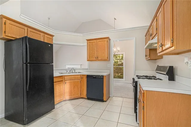 a kitchen with stainless steel appliances granite countertop a refrigerator a stove and a sink