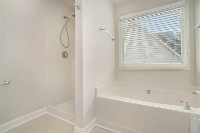 a bathroom with a bath tub with a shower