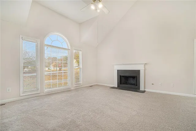 an empty room with windows and fireplace