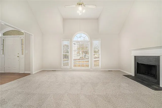 an empty room with windows and fireplace