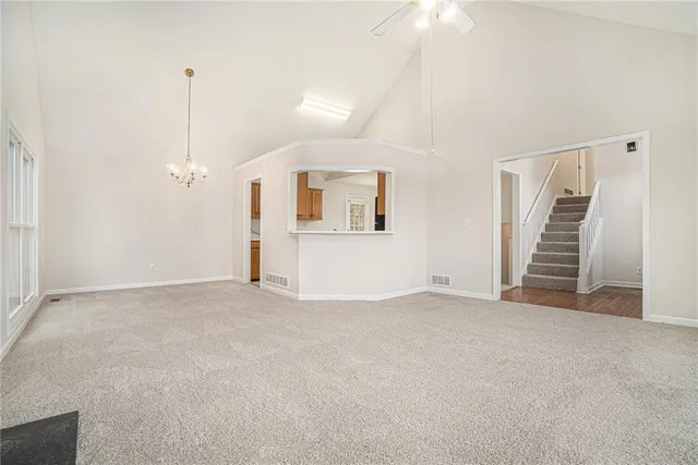 an empty room with windows and stairs