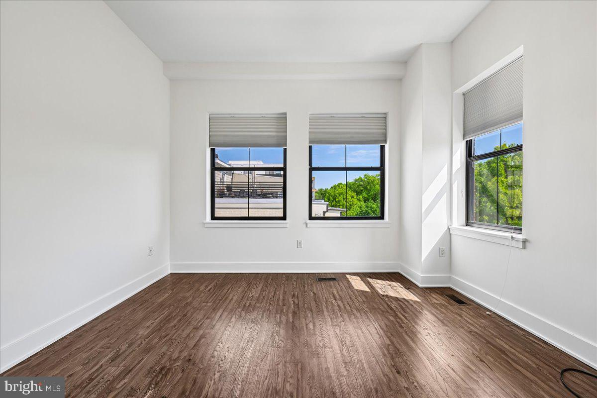 1111 W Street Northwest, Unit 12 Washington, DC 20009 - Photo 31 of 50 an empty room with wooden floor and windows