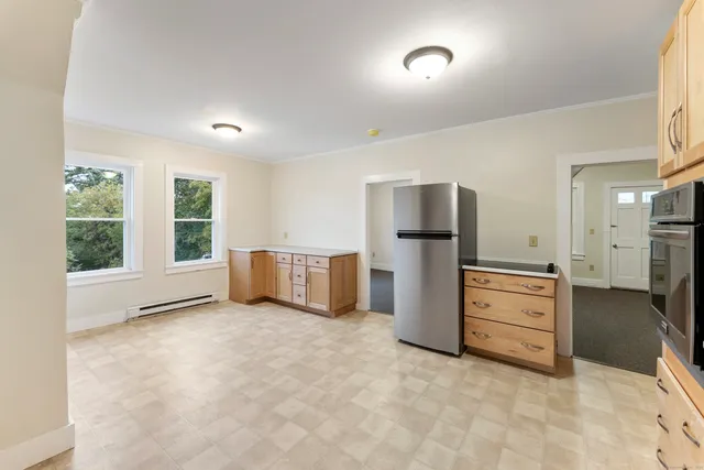 a view of a kitchen with refrigerator stove and wooden floor