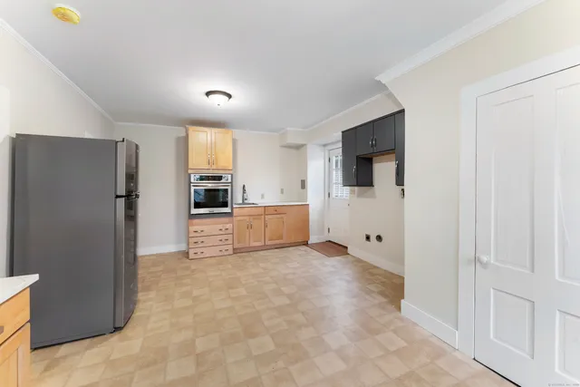 a view of a kitchen with refrigerator and an oven