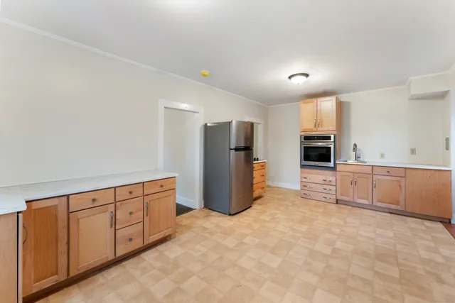a kitchen with granite countertop white cabinets and refrigerator