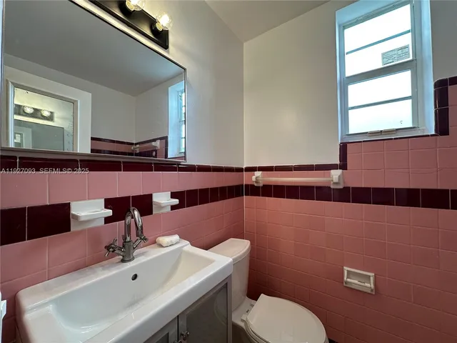 a bathroom with a sink mirror and toilet