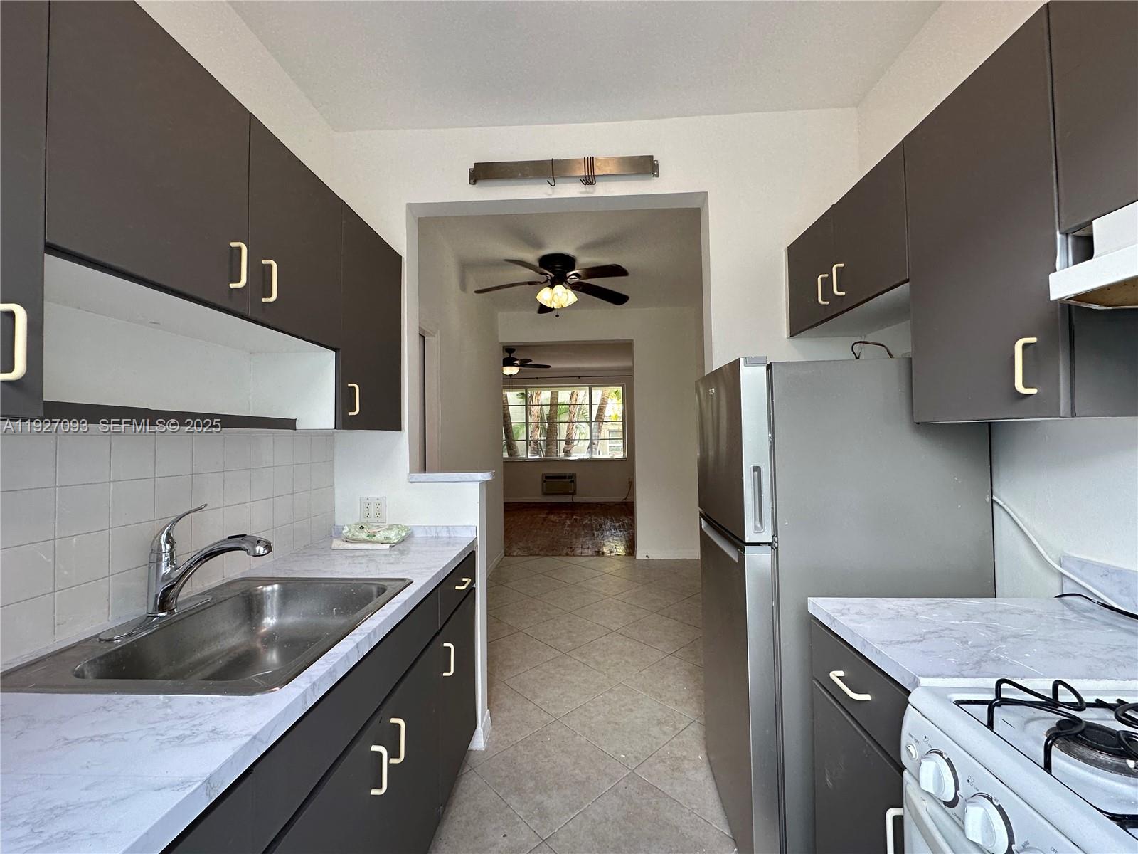 1540 Euclid Avenue, Unit 103 Miami Beach, FL 33139 - Photo 20 of 22 a kitchen with a sink stove and refrigerator