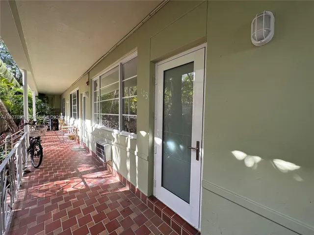 a view of a hallway with wooden floor and a dining room