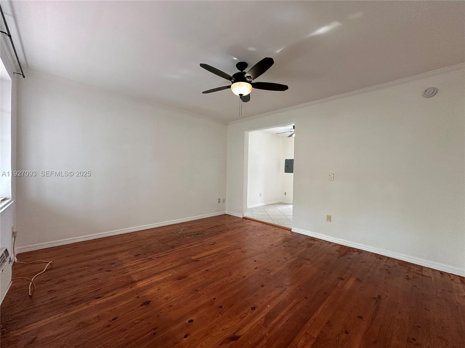 1540 Euclid Avenue, Unit 103 Miami Beach, FL 33139 - Photo 6 of 22 an empty room with wooden floor and windows