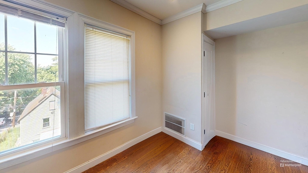 2973 Washington Street, Unit 3 Boston, MA 02119 - Photo 6 of 6 a view of an empty room with wooden floor and a window